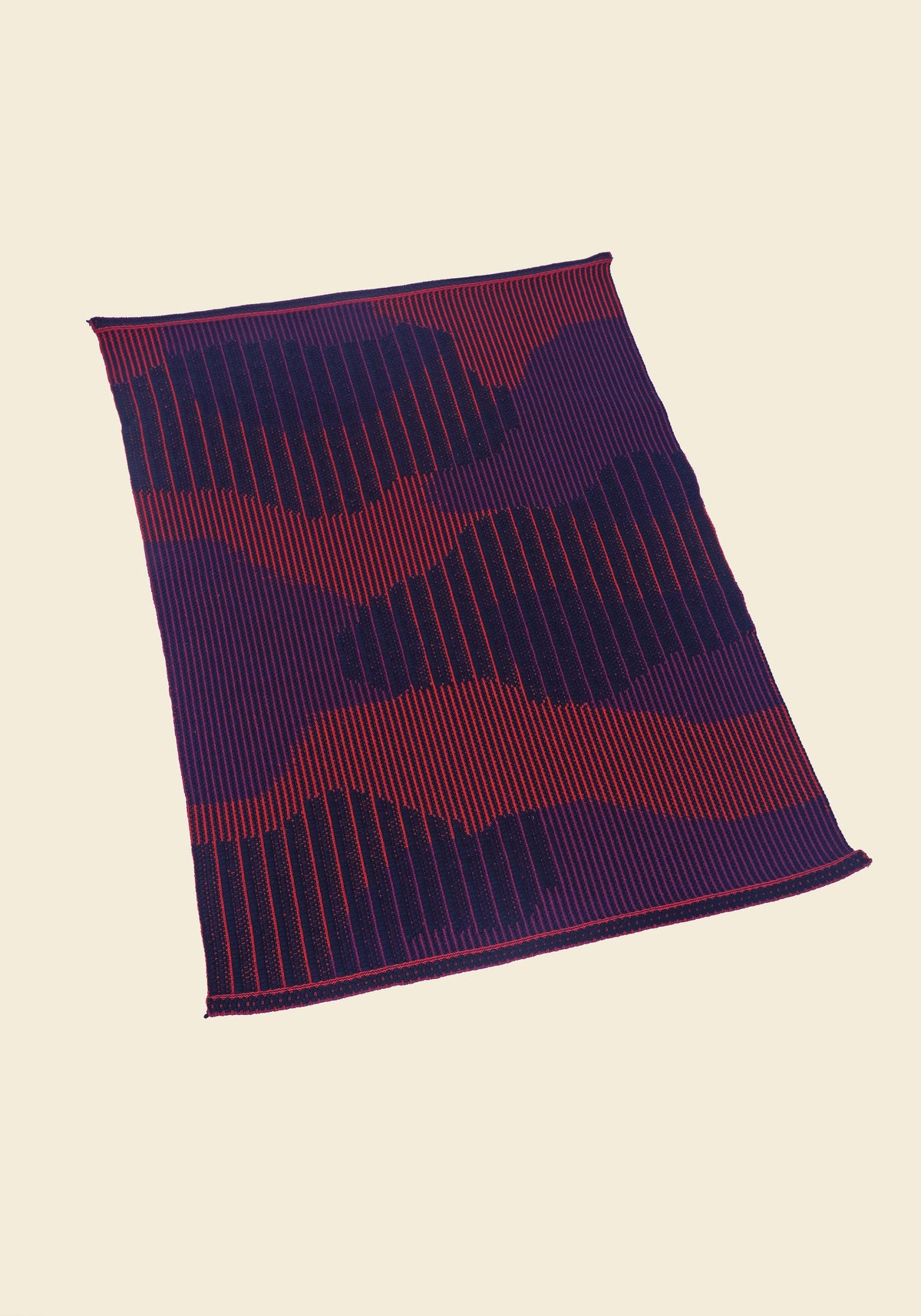top side view of red knit organic cotton table mat with abstract design