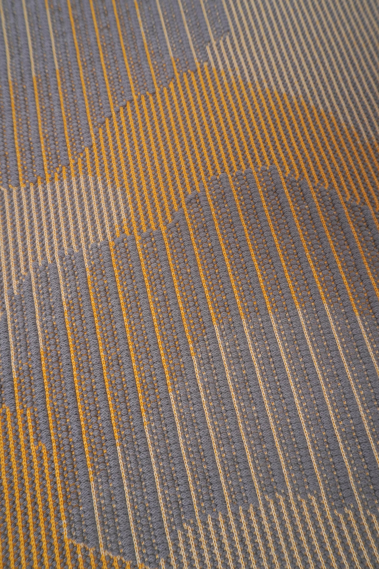 detail of yellow knit organic cotton table mat with abstract design