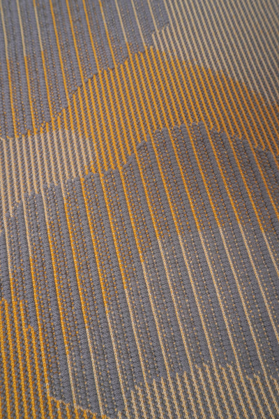 detail of yellow knit organic cotton table mat with abstract design
