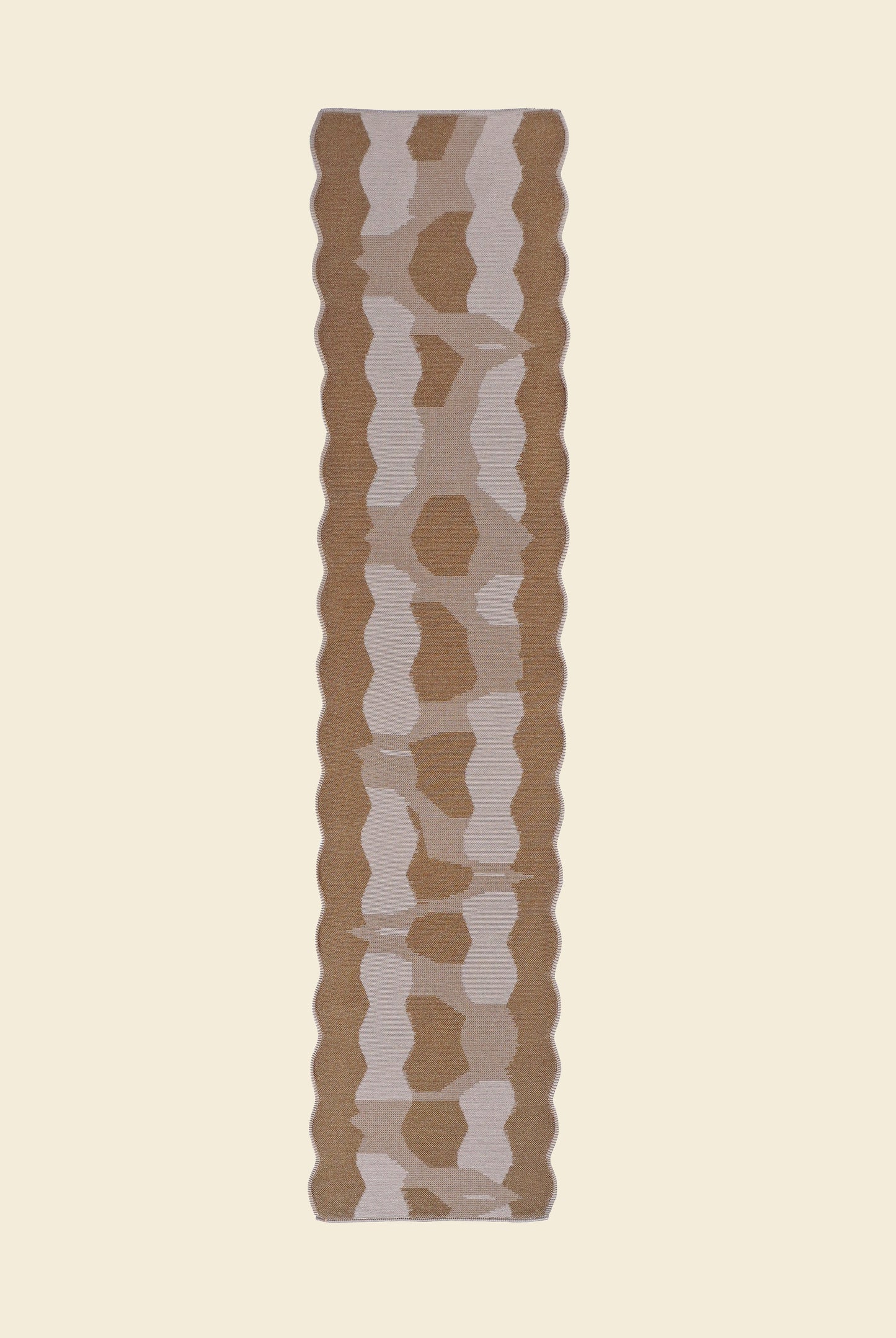back side top view of beige knit organic cotton and viscose table runner with abstract pattern and wavy edges