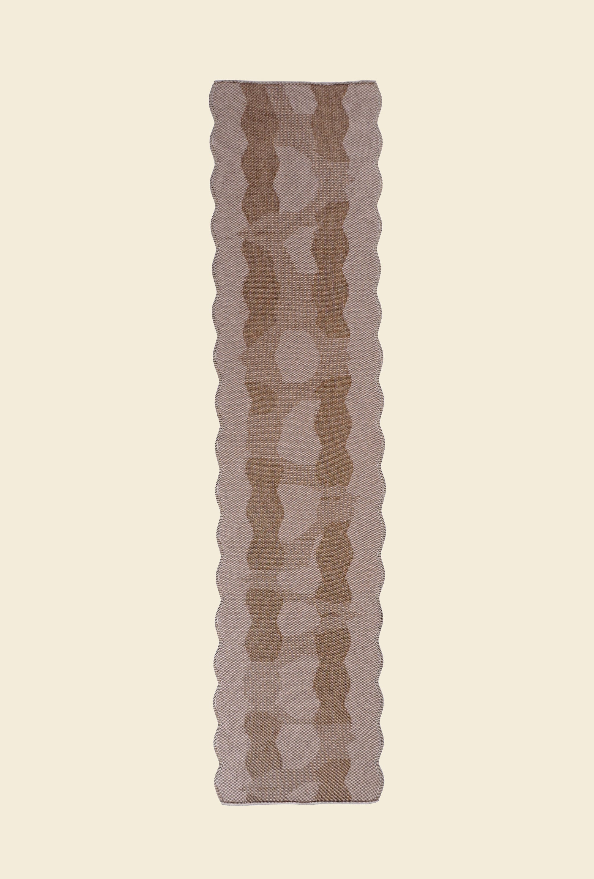 top view of beige knit organic cotton and viscose table runner with abstract pattern and wavy edges