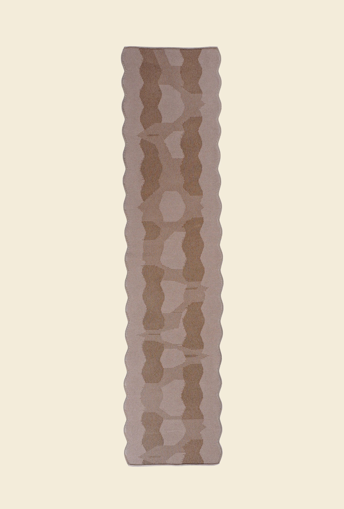 top view of beige knit organic cotton and viscose table runner with abstract pattern and wavy edges