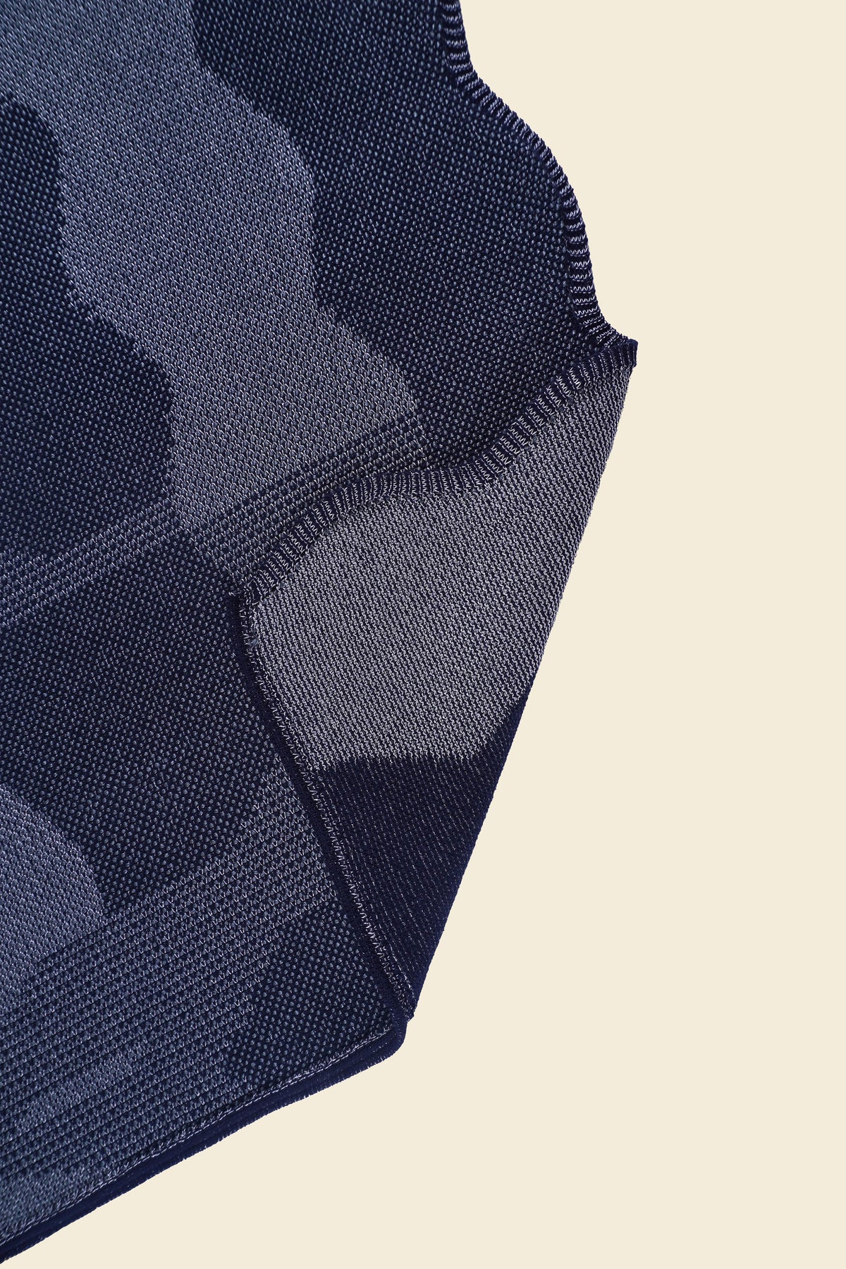 corner of grey knit organic cotton and viscose table runner with abstract pattern and wavy edges