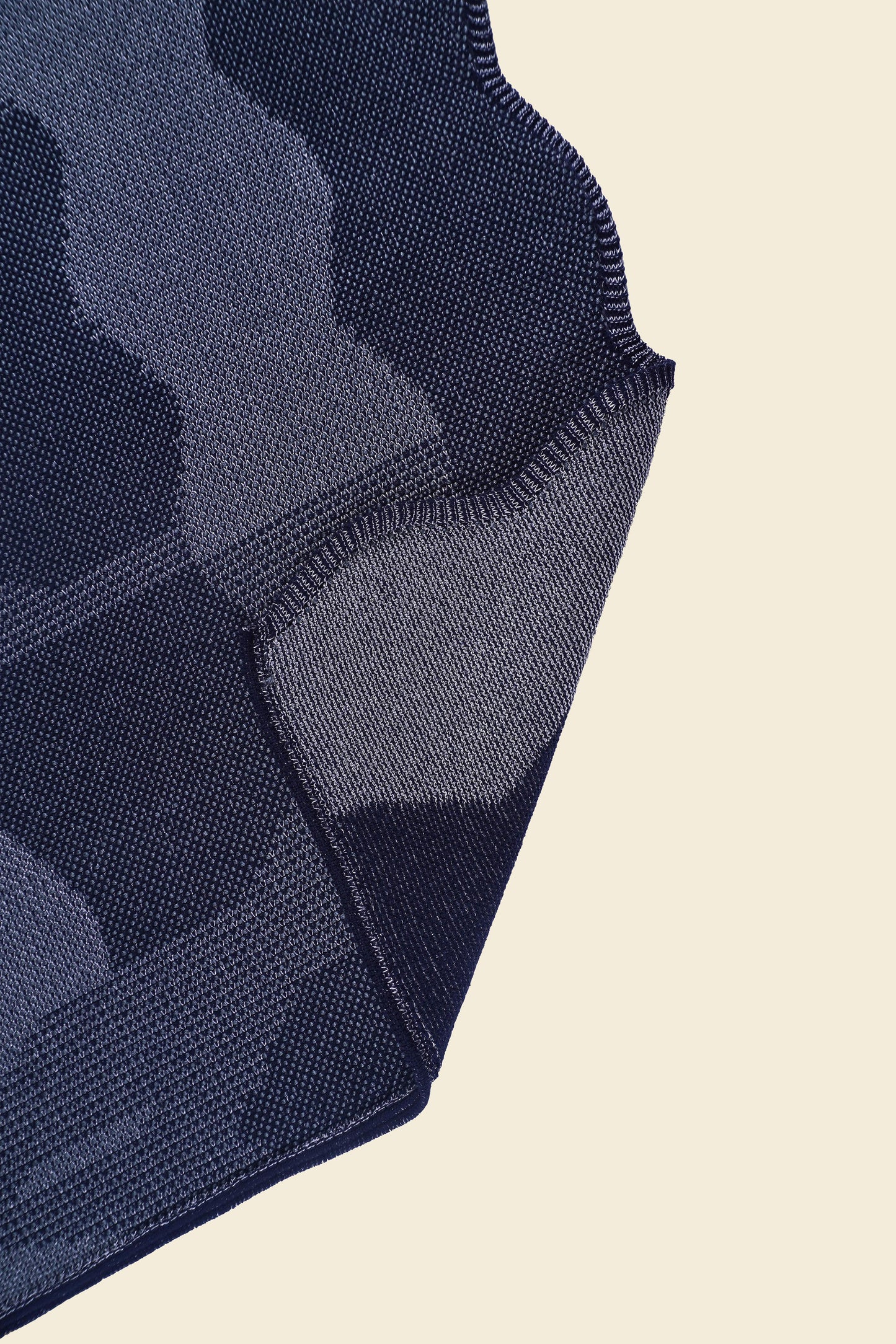 corner of grey knit organic cotton and viscose table runner with abstract pattern and wavy edges