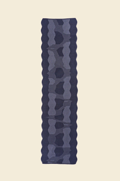top view of grey knit organic cotton and viscose table runner with abstract pattern and wavy edges