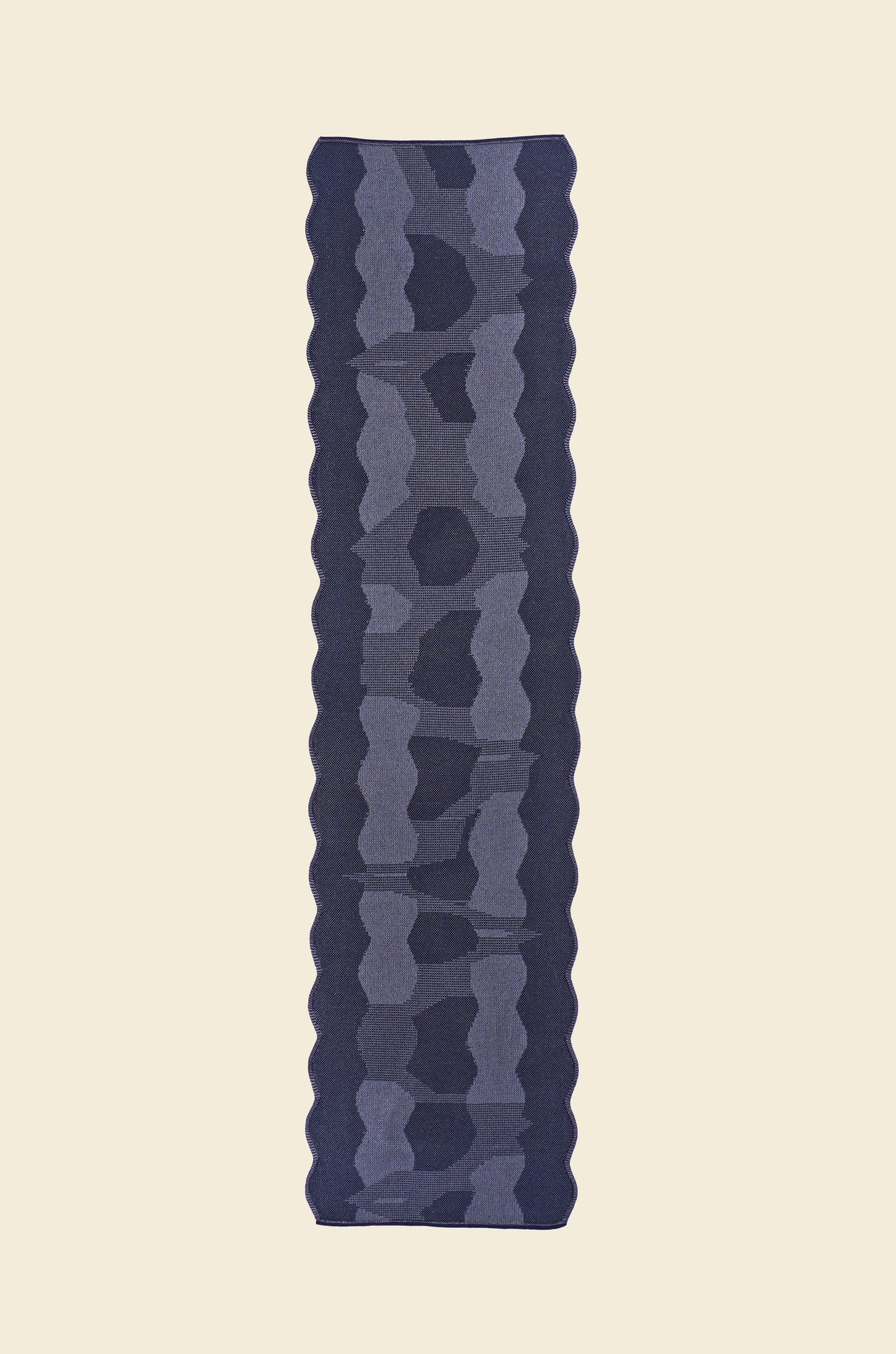 top view of grey knit organic cotton and viscose table runner with abstract pattern and wavy edges