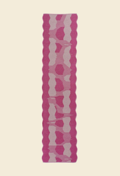 back top view of pink knit organic cotton and viscose table runner with abstract pattern and wavy edges