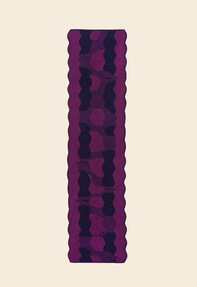 back side top view of purple knit organic cotton and viscose table runner with abstract pattern and wavy edges