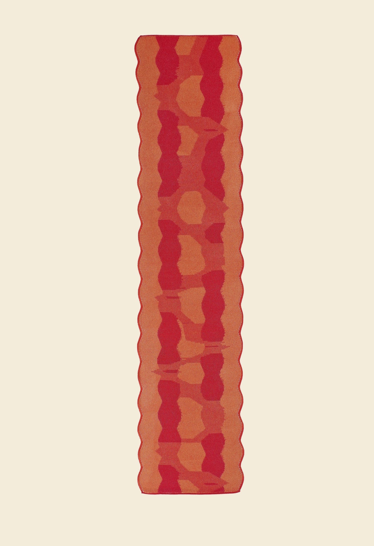 back side of red knit organic cotton and viscose table runner with abstract pattern and wavy edges