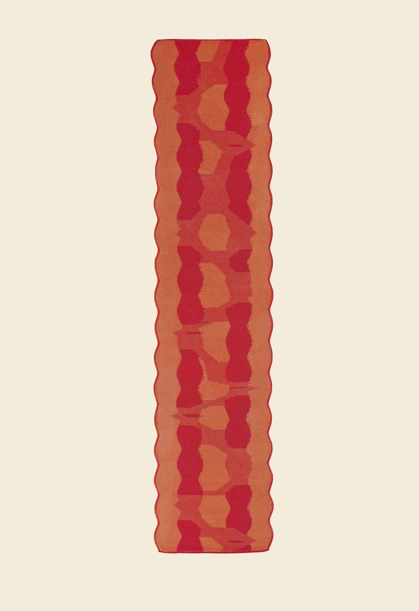 back side of red knit organic cotton and viscose table runner with abstract pattern and wavy edges