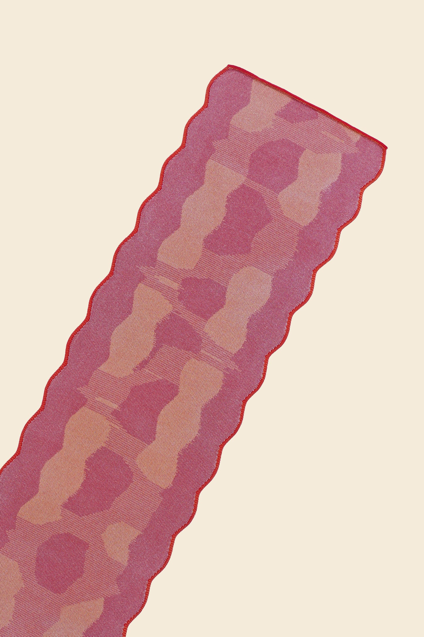 top close-up of red knit organic cotton and viscose table runner with abstract pattern and wavy edges