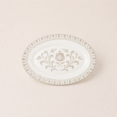 Decorative white plate with intricate gold patterns on a beige background