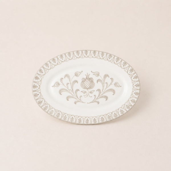 Decorative white plate with intricate gold patterns on a beige background