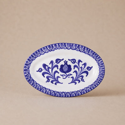 Oval ceramic plate with blue floral design on a beige background
