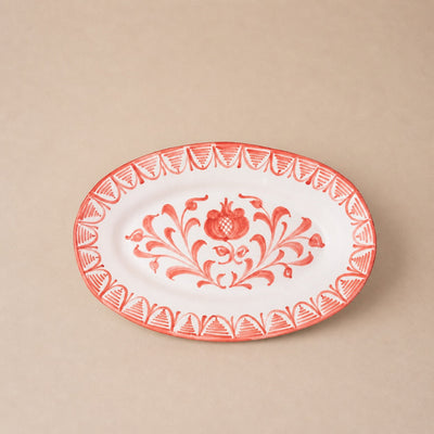 Decorative plate with red floral design on a beige background