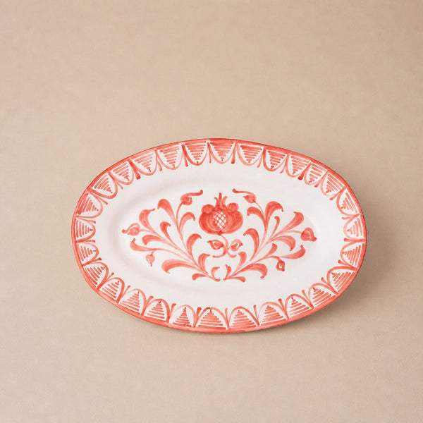 Decorative plate with red floral design on a beige background