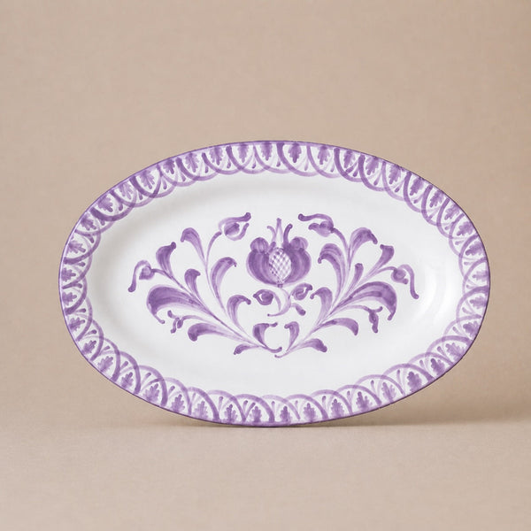 Oval ceramic plate with purple floral design on a beige background