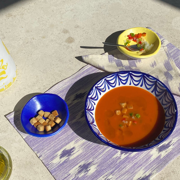 Bowls of soup and a side dish on a linnen placemat - lifestyle