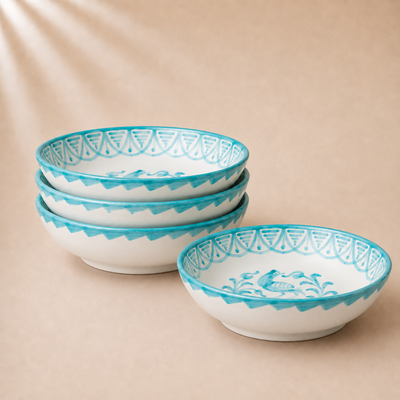 Set of four ceramic bowls with blue decorative patterns on a beige background