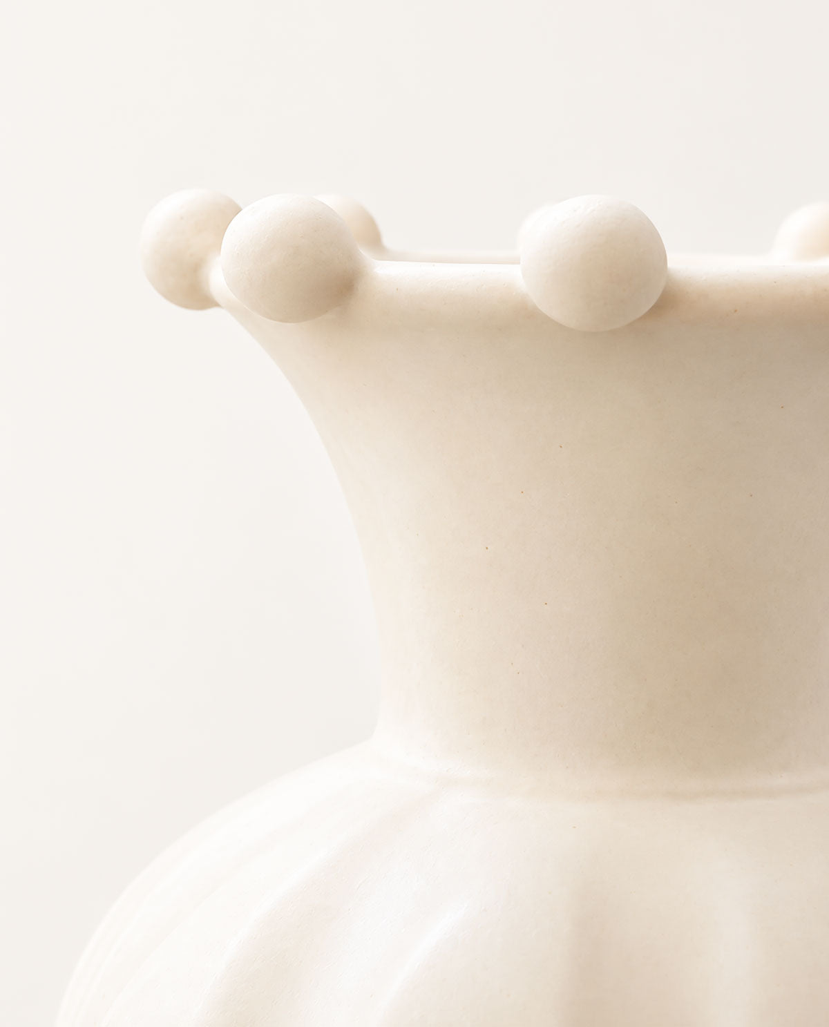 Macro view of the Pearl handmade ceramic vase highlighting its soft matte white glaze, curved neck and pearl-like details.