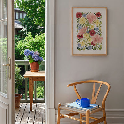 petunia blooms art print styled on blank wall in a2 by the garden with flower pots, books and a wooden chair