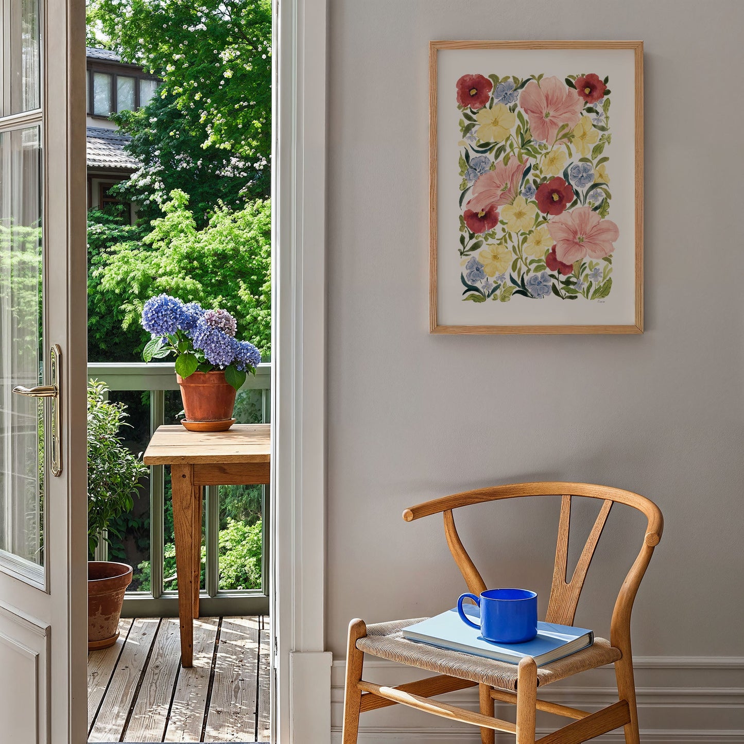 petunia blooms art print styled on blank wall in a2 by the garden with flower pots, books and a wooden chair
