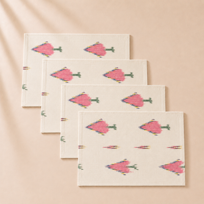 Set of four folded napkins with pink floral patterns on a beige background