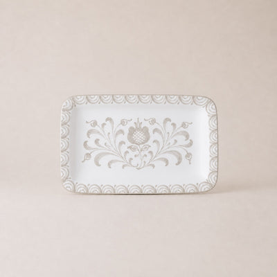 Decorative white plate with floral patterns on a beige background