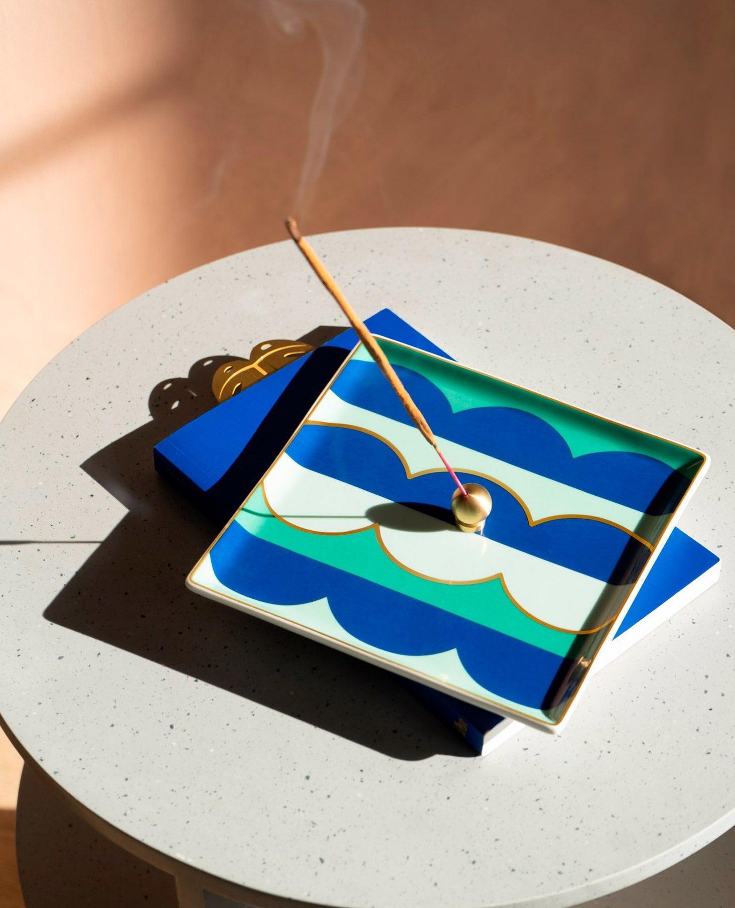 The OCTAEVO Riviera Wave Ceramic Tray’s blue, green & gold design elevates your table—a stylish gift for incense lovers.