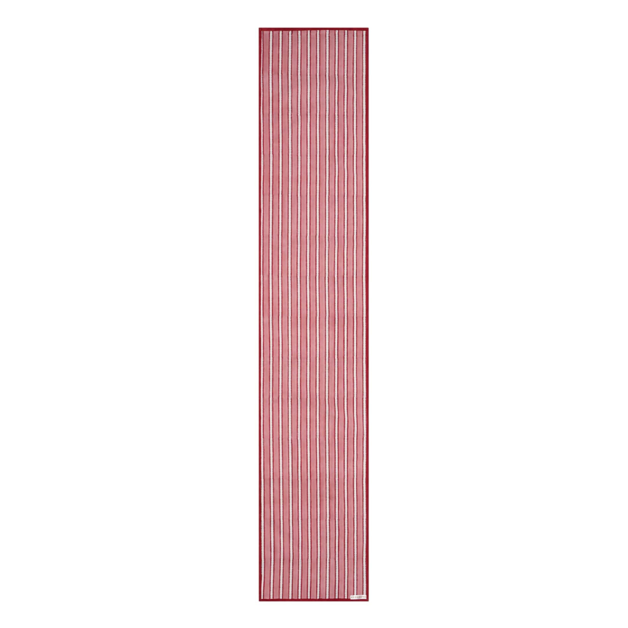A striped cotton table runner with a classic design, predominantly in red and white colors, displayed on a table.