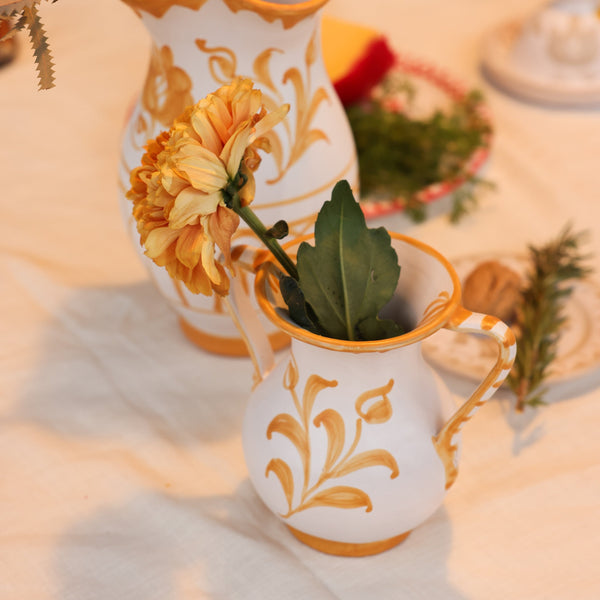 Decorative white vases with gold floral patterns on a table setting. - lifestyle