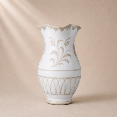 White ceramic vase with beige floral patterns on a beige background