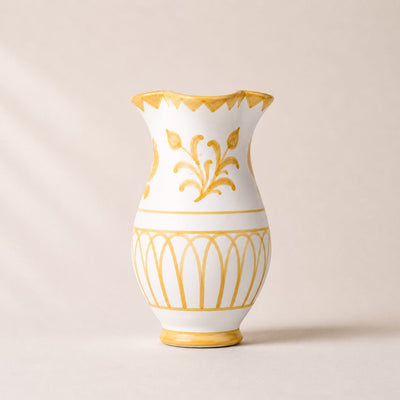 White vase with gold decorative patterns on a beige background