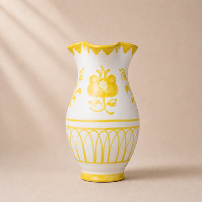 White vase with yellow floral patterns on a beige background
