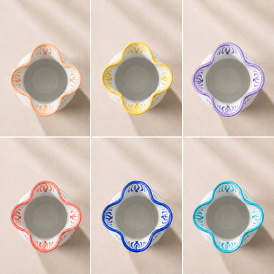 Set of six ceramic bowls with colorful decorative rims on a beige background - lifestyle