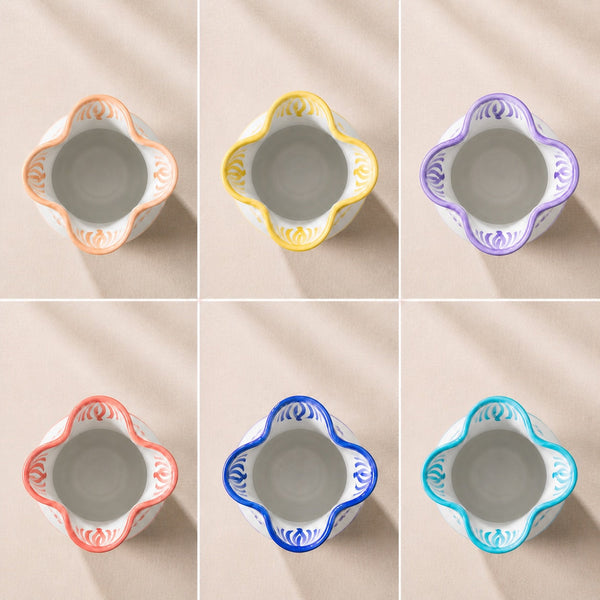 Set of six ceramic bowls with colorful decorative rims on a beige background - lifestyle
