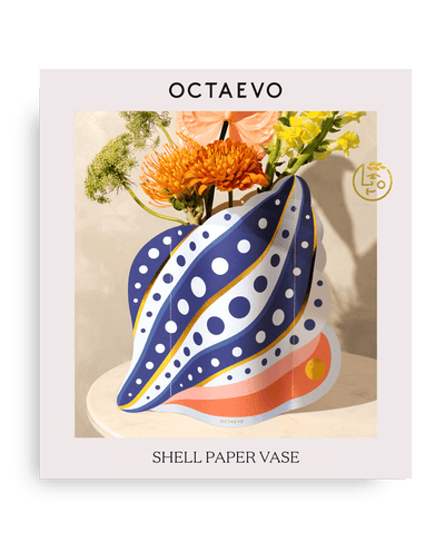 Octaevos Shell Paper Vase with polka dots sits on a table, holding orange and yellow flowers.