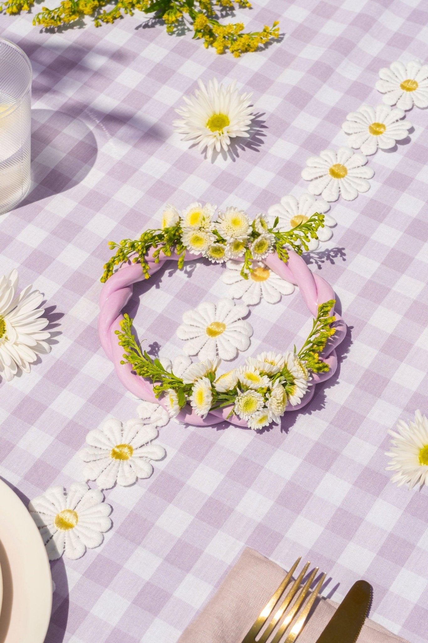 The OCTAEVO Sicilia Ceramic Trivet rests on a purple gingham tablecloth beside decorative wreath accents.