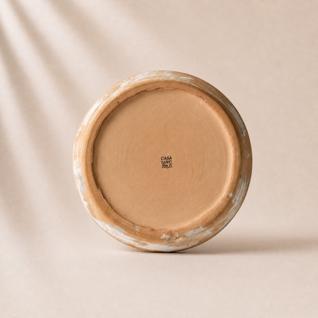 Round ceramic plate with a beige color on a beige background - lifestyle