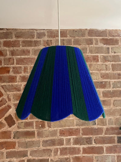 A Slice Shades handwoven yarn striped Scallop Lampshade in the sun in Cobalt Blue & Emerald Green.
