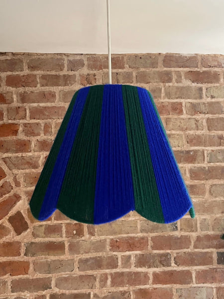 A Slice Shades handwoven yarn striped Scallop Lampshade in the sun in Cobalt Blue & Emerald Green.