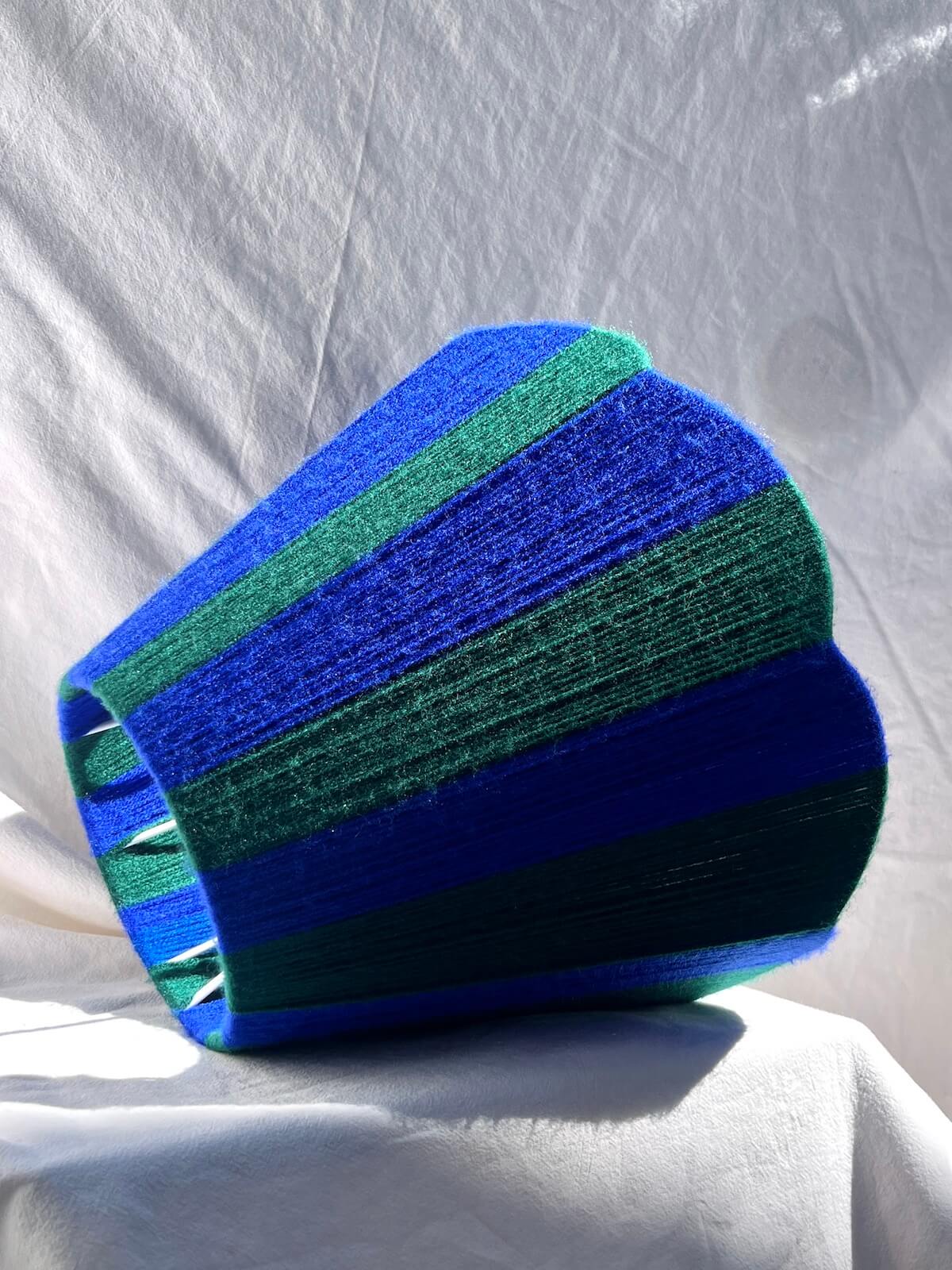 A Slice Shades handwoven yarn striped Scallop Lampshade in the sun in Cobalt Blue & Forest Green.