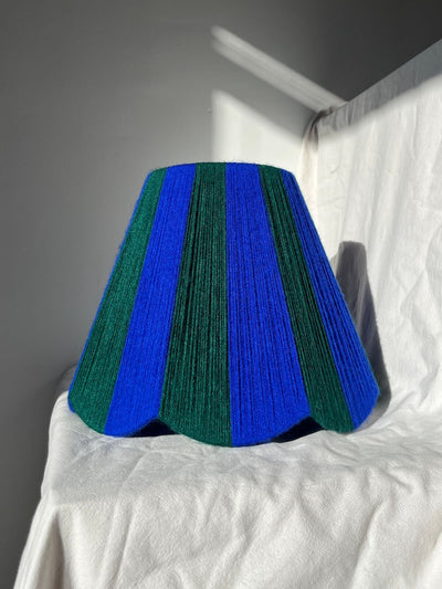 A Slice Shades handwoven yarn striped Scallop Lampshade in the sun in Cobalt Blue & Emerald Green.