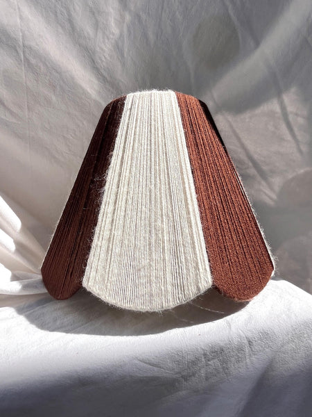 A handmade yarn scallop lampshade by Slice Shades in Ecru and Cocoa white and brown.