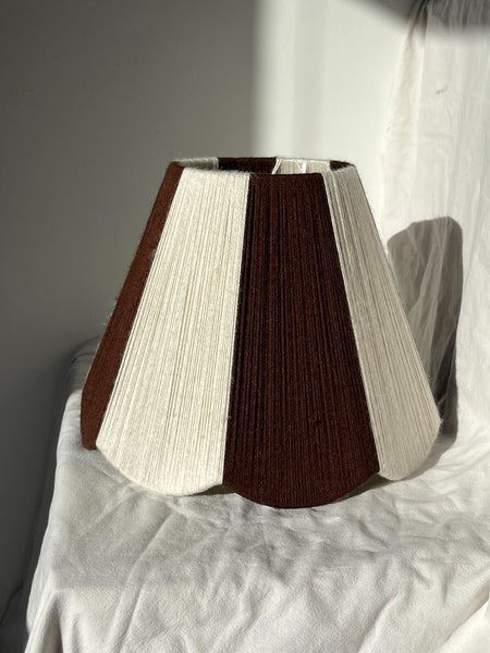 A handmade yarn scallop lampshade by Slice Shades in Ecru and Cocoa white and brown.
