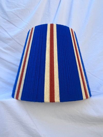 A Slice Shades handwoven striped yarn lampshade in cobalt blue, butter yellow and burnt orange stripes.