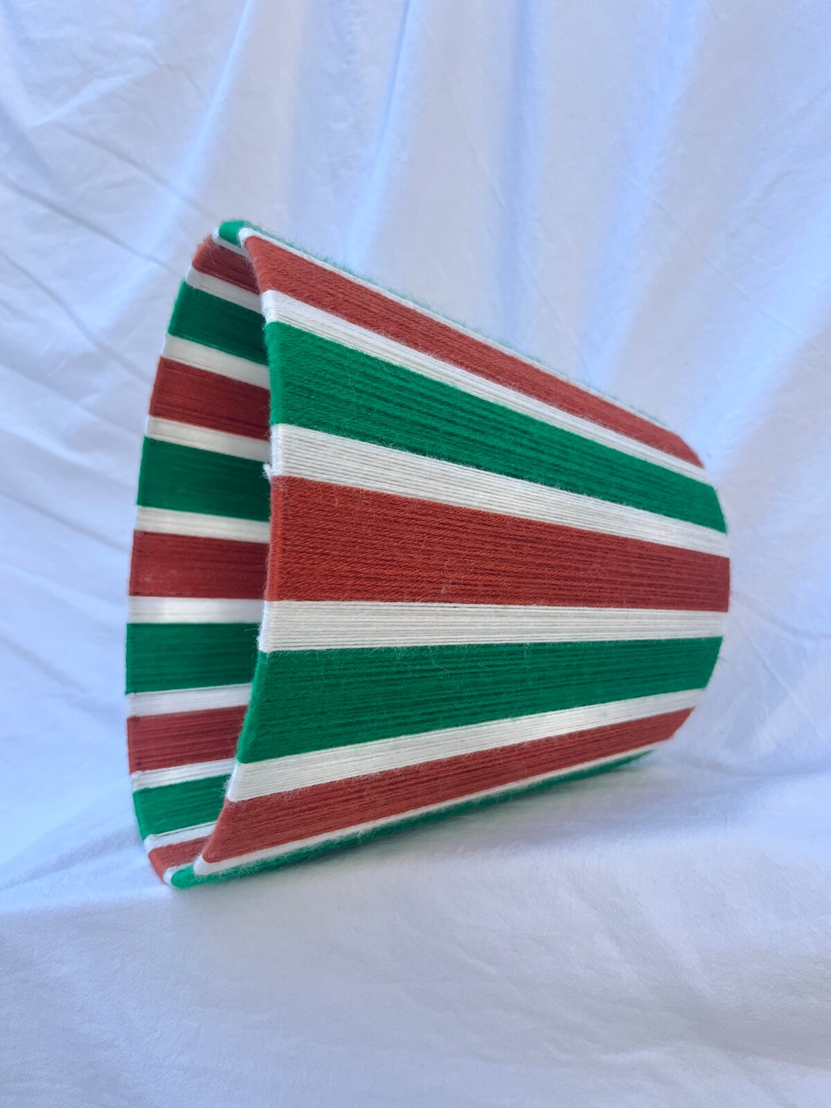 A Slice Shades handwoven yarn striped lampshade in Rust, Ecru & Jade Green on a white background.