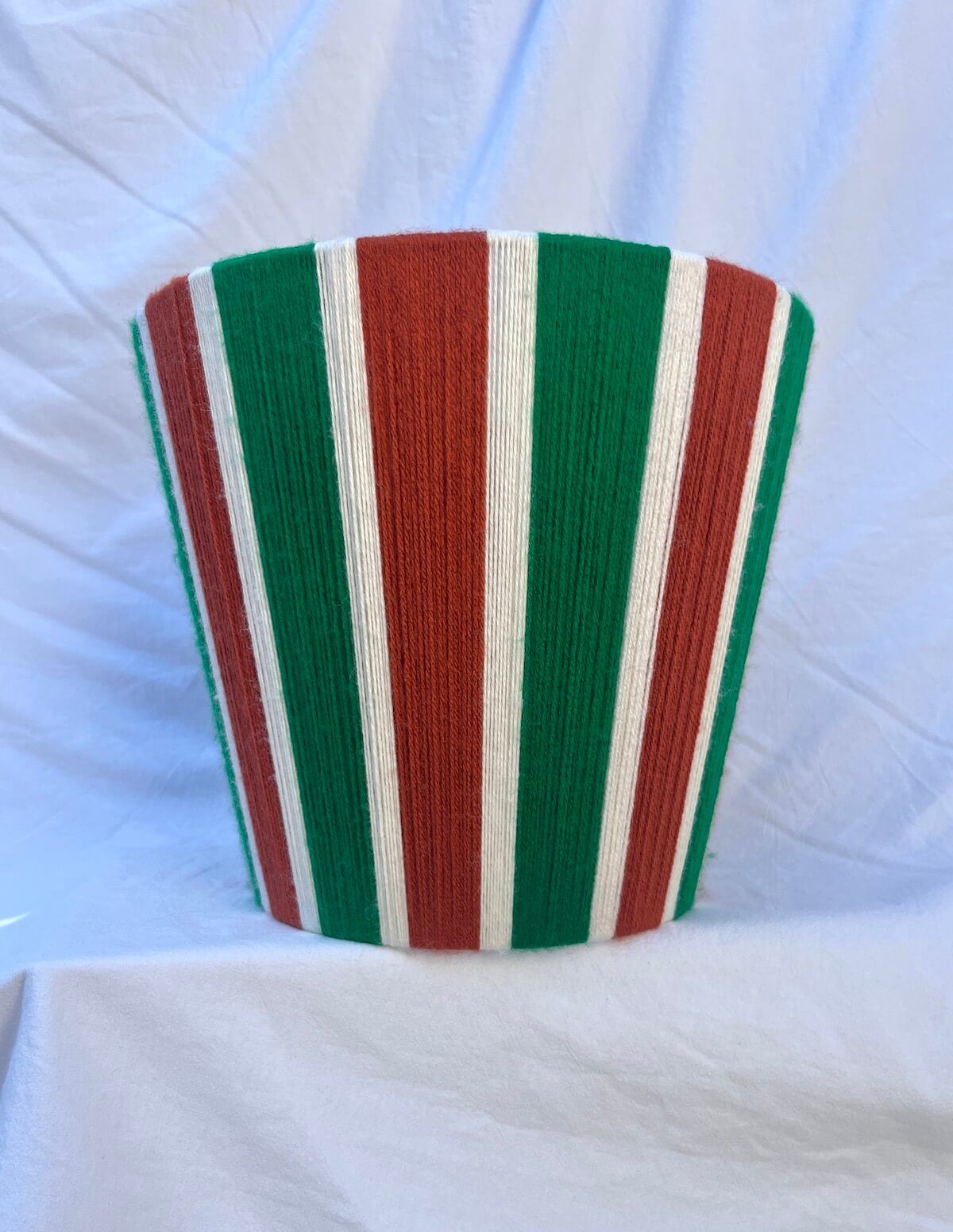 A Slice Shades handwoven yarn striped lampshade in Rust, Ecru & Jade Green on a white background.