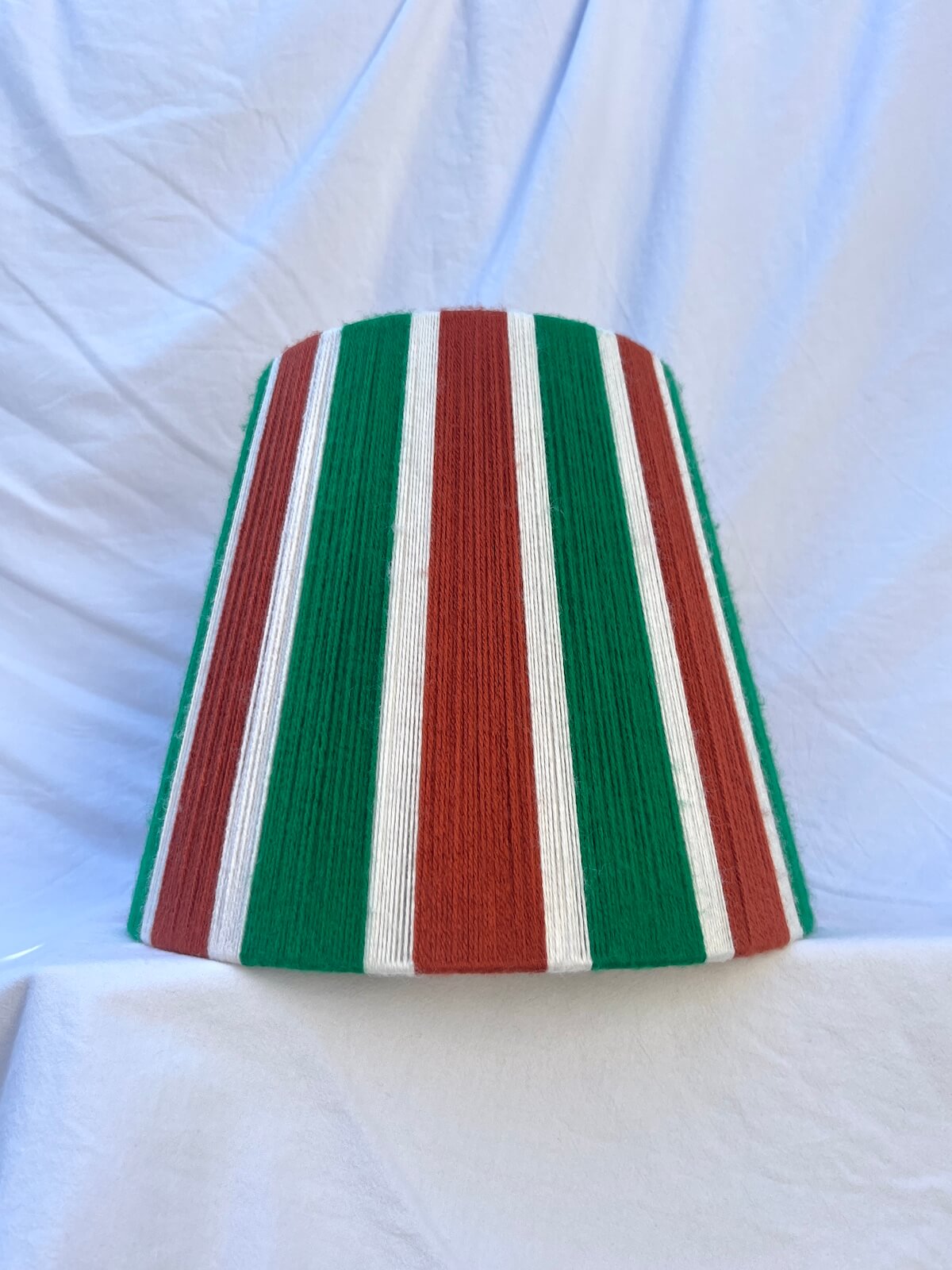 A Slice Shades handwoven yarn striped lampshade in Rust, Ecru & Jade Green on a white background.