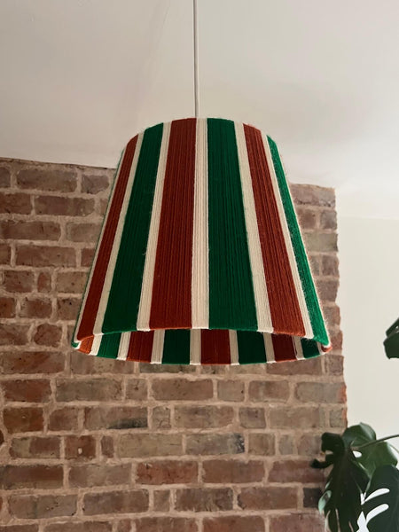 A Slice Shades handwoven yarn striped lampshade in Rust, Ecru & Jade Green on a white background.